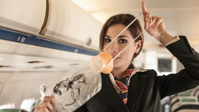 Air stewardess performing safety demonstration on aeroplane