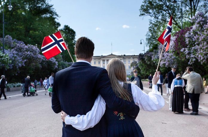may-17th-festivities-norway-couple-flags-940x620-1