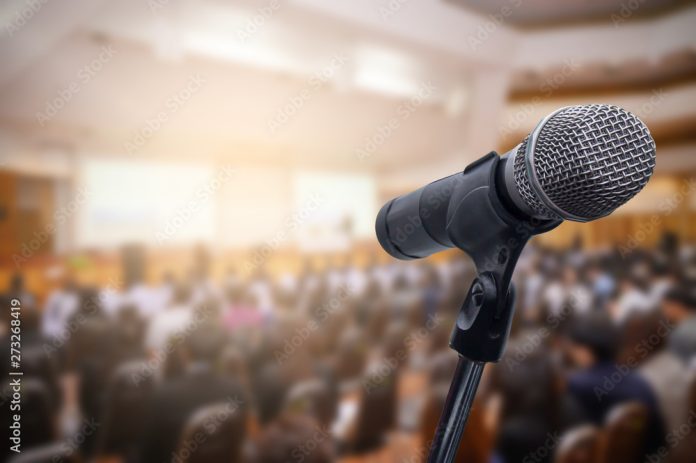 microphone-over-the-blurred-business-people-forum-meeting-conference-training-learning-coaching-concept-blurred-background-stockpack-adobe-stock Microphone over the blurred business people forum Meeting Conference Training Learning Coaching Concept, Blurred background.