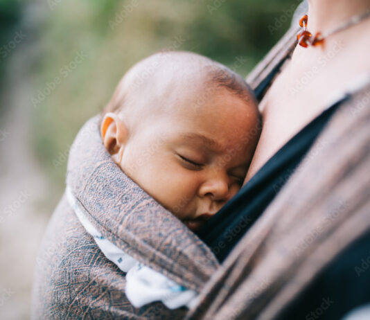– Forventer en offentlig unnskyldning etter granskingen Blonde caucasian mom holding her colored child in a sling